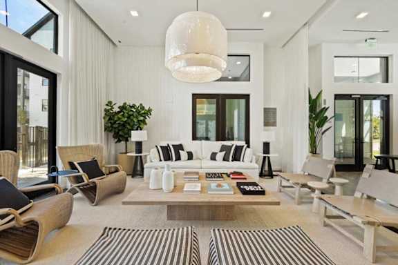 A modern living room with a large sofa, armchairs, and a coffee table.