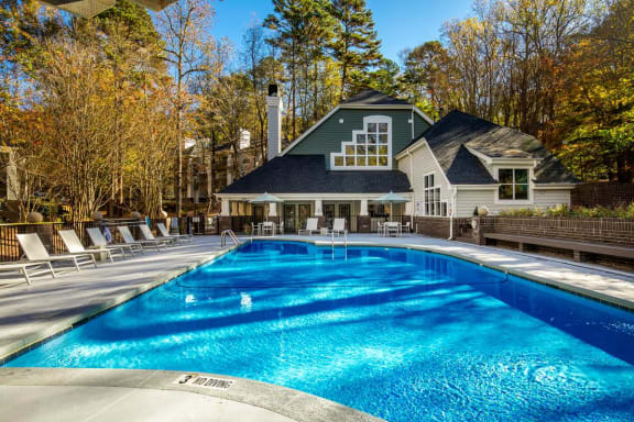 a swimming pool with a house in the background