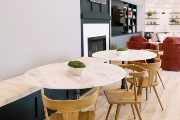 a room with a table and chairs and a couch in the background
