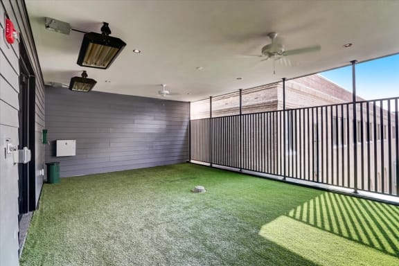 a yard with artificial grass and a ceiling fan
