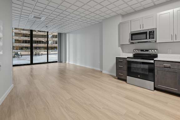 A kitchen with a white ceiling and wooden floors at Hampton Plaza Apartments, Towson, MD, 21286