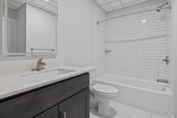 A white bathroom with a toilet, sink, and bathtub at Hampton Plaza Apartments, Towson, MD, 21286