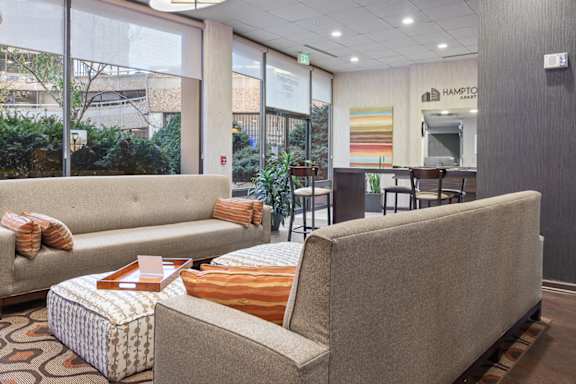 A patio with a table and chairs overlooks a city street at Hampton Plaza Apartments, Towson, MD, 21286
