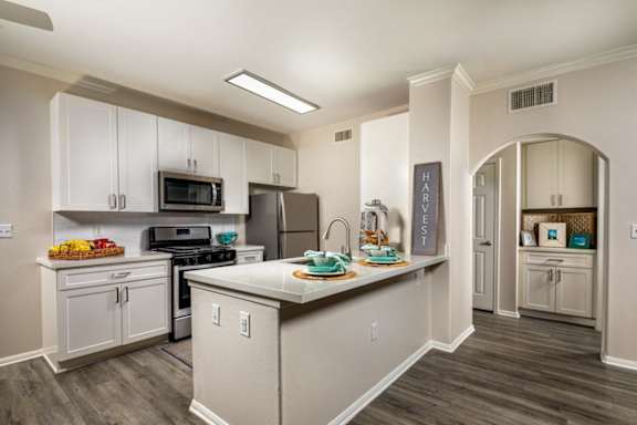 a kitchen with white cabinets and a large counter top