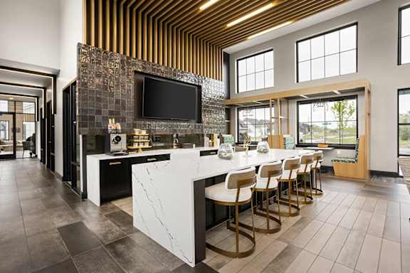 a large kitchen with a marble counter top and bar stools at Slate at Fishers District, Fishers, 46037