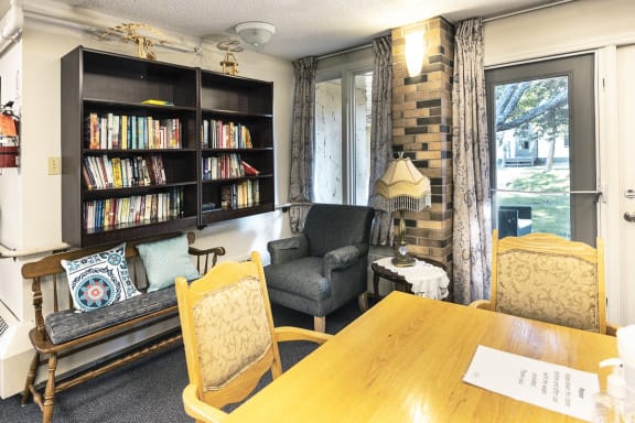 a living room with a bookshelf and a dining table