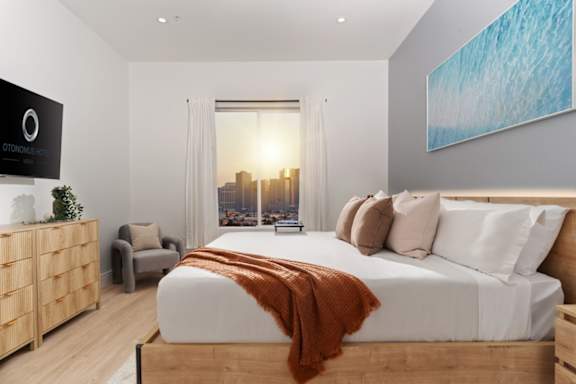 A bedroom with a large bed and a view of the city.