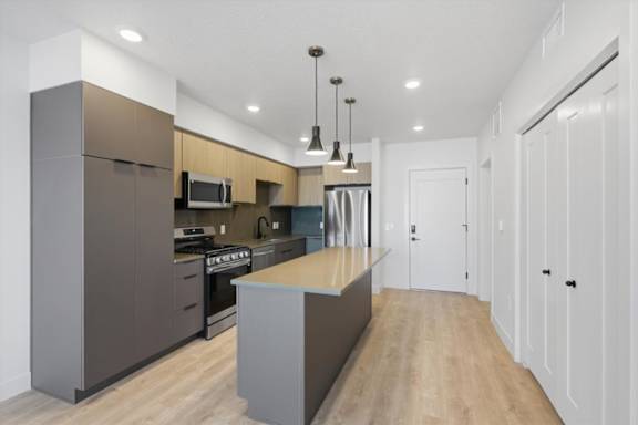 A modern kitchen with a large island in the middle at Brickside Heights, Millcreek