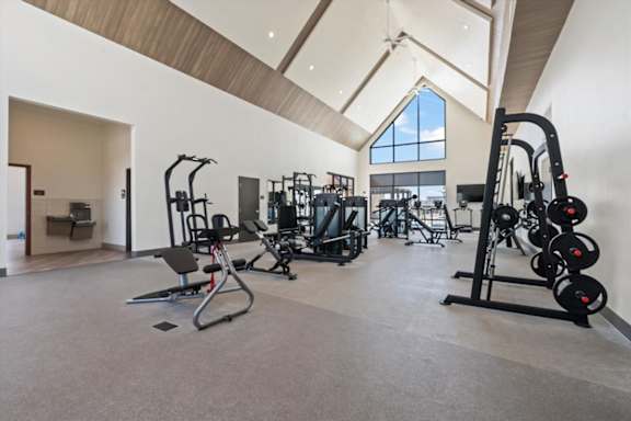 A spacious gym with a variety of equipment including treadmills, weight machines, and free weights at Solhavn Apartments, American Fork, UT