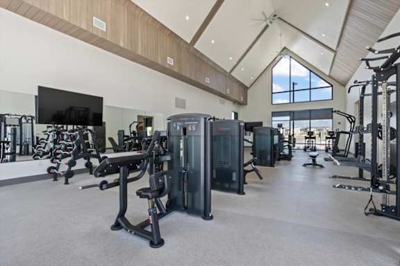A spacious gym with a variety of equipment and a flat screen TV mounted on the wall at Solhavn Apartments, Utah 84003