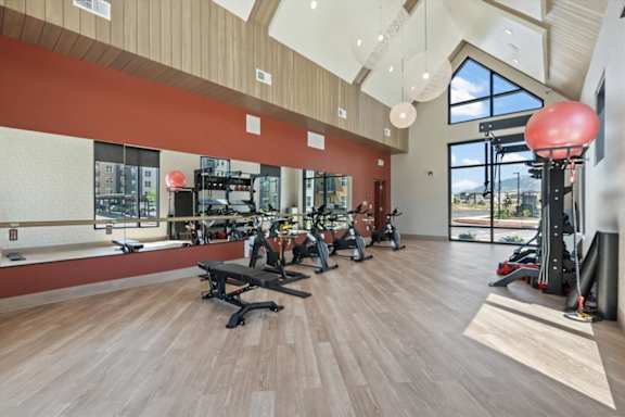 A gym with a variety of equipment including treadmills, weights, and exercise machines at Solhavn Apartments, American Fork, UT, 84003
