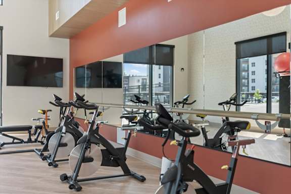 A gym with stationary bikes and a flat screen TV at Solhavn Apartments, American Fork