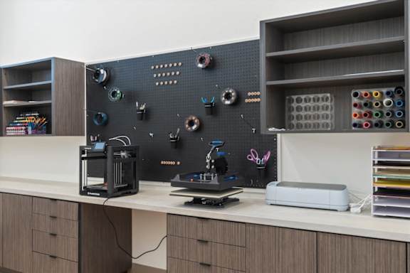 A workspace with a 3D printer, a monitor, and a keyboard at Solhavn Apartments, American Fork
