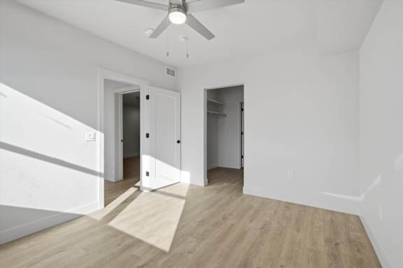 A room with a ceiling fan and two doors at Brickside Heights, Millcreek, 84106