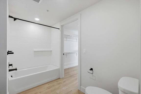 A white bathroom with a toilet, sink, and bathtub at Brickside Heights, Millcreek, Utah