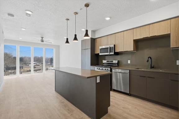 A kitchen with a large island and a microwave above it at Brickside Heights, Millcreek, 84106