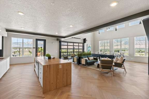 A spacious living room with a wooden floor and a large island in the middle at Solhavn Apartments, American Fork, 84003