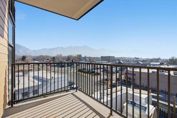 A balcony with a view of a parking lot and mountains at Brickside Heights, Millcreek