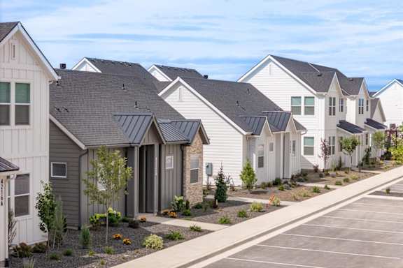 A row of houses with grey roofs and white walls. at Alante Homes at Spring Run, Idaho