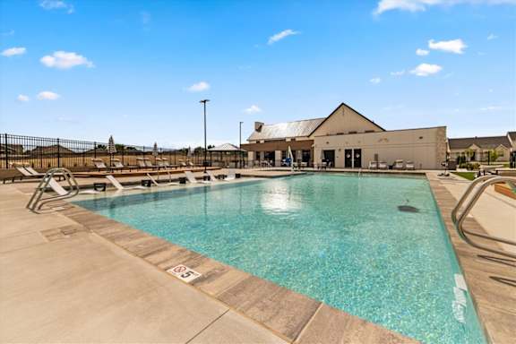 A large outdoor swimming pool with a building in the background at Alante Homes at Spring Run, Caldwell, ID, 83607