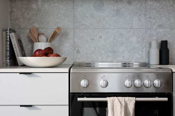 a kitchen with a stove and a bowl of fruit