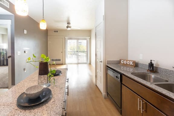 an open kitchen and living room with a sink and counter top