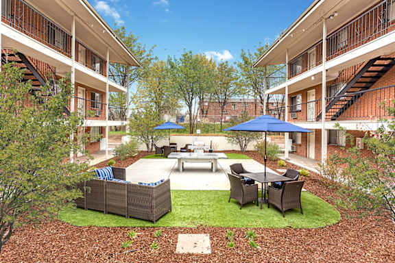 A courtyard with a table and chairs surrounded by buildings.