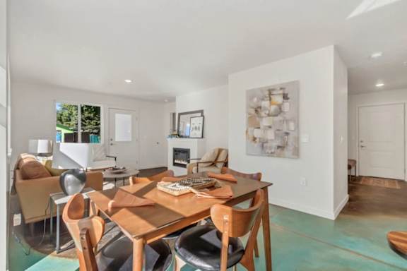 A modern dining room with a wooden table and chairs.