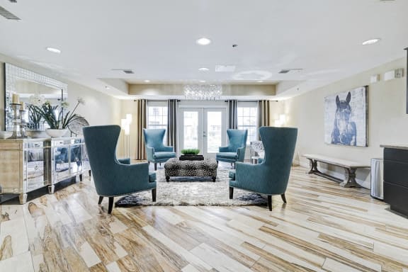 a living room with blue chairs and a rug