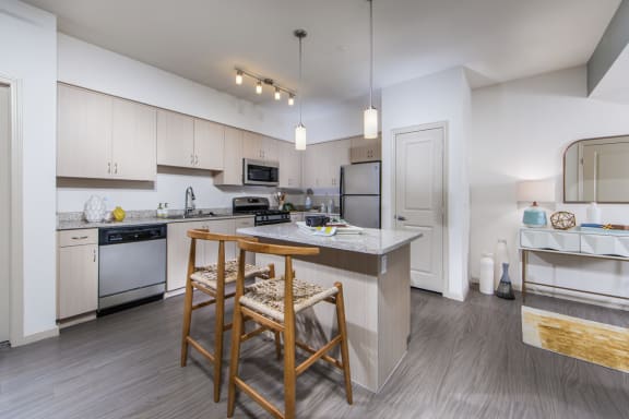 a kitchen with white cabinets and a island with two stools