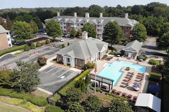 an aerial view of the resort style pool and hot tub with lounge chairs and umbrellas at Centerville Manor Apartments in Virginia Beach