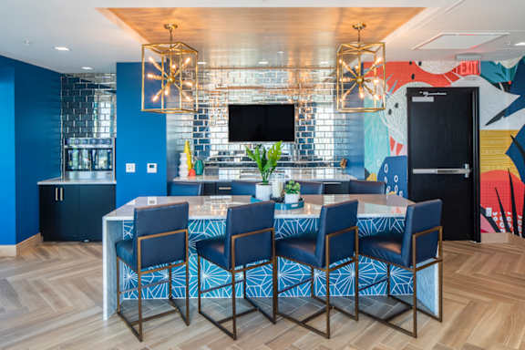 The modern lobby at Lake Nona Pixon Apartments with ample seating, games, and multiple murals