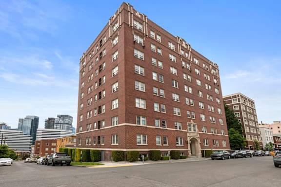 A large red brick building with a parking lot in front.