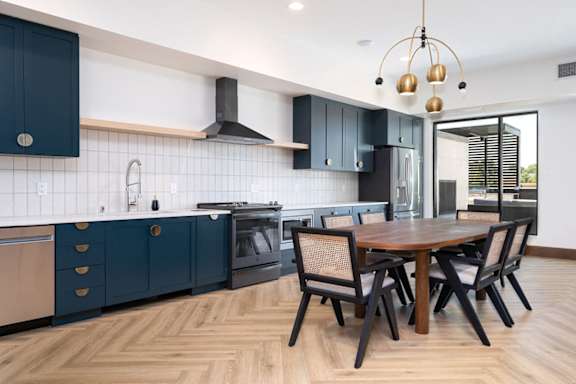 a kitchen with blue cabinets and a wooden table and chairs