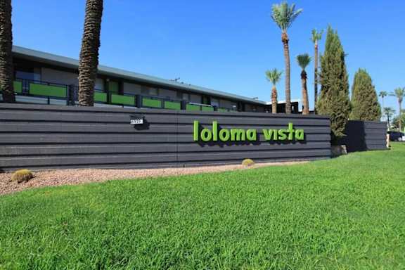 A building with a sign that says "Ioloma Vista" in front of some trees.