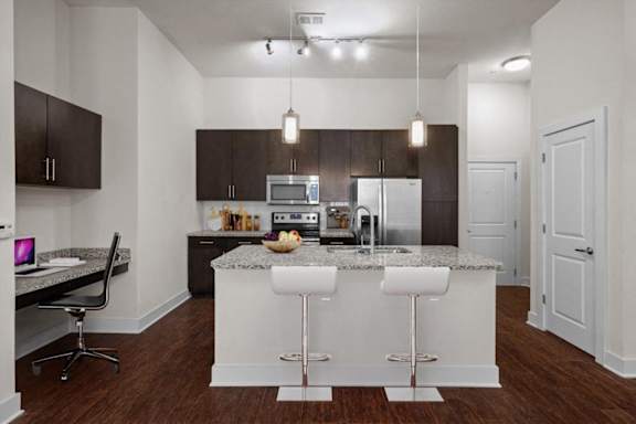 a kitchen with an island and a table with chairs at West 39th Street Apartments, Kansas City, 64111