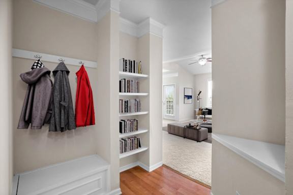 a hallway with a closet with clothes hanging on the wall and a staircase at Stonepost Ranch, Overland Park, KS, 66221