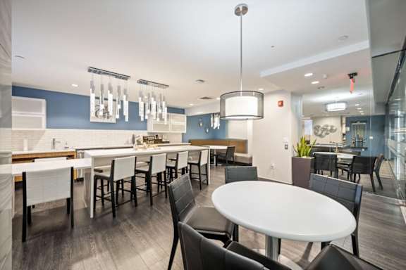 Resident lounge at Sky on Main in Downtown Kansas City featuring communal tables, bar seating, pendant lighting, and workspace areas.