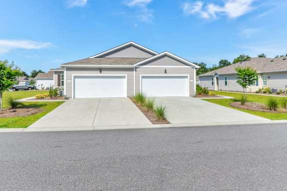A house with a grey roof and two garages.