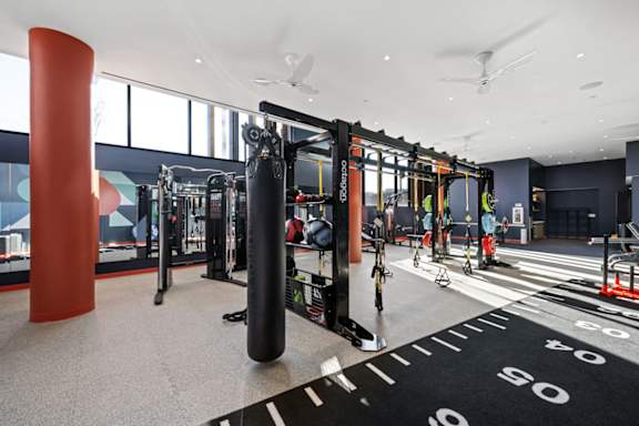 A gym with a variety of equipment including a punching bag.