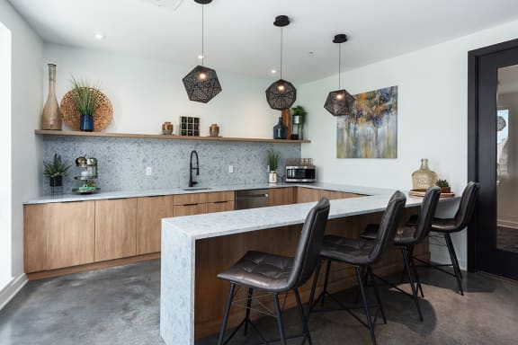 a kitchen with a bar and chairs in front of it