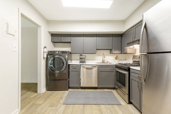 a kitchen with gray cabinets and stainless steel appliances at Copper and Quarry Village, Pikesville, MD, 21209