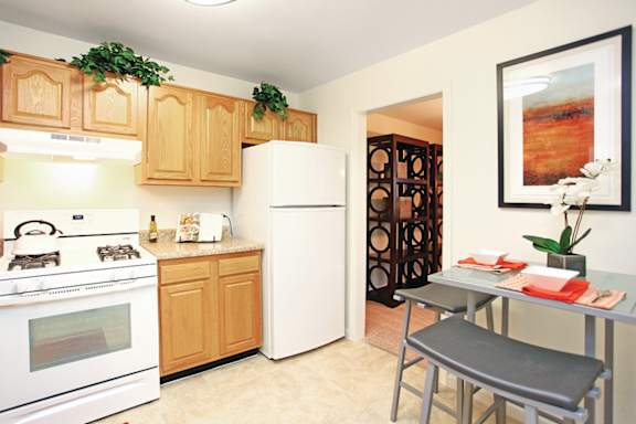 A kitchen with a white stove and a white refrigerator. at Copper and Quarry Village, Pikesville, 21209