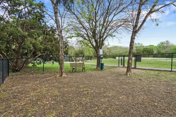 a park with a bench and trees and a fence at Radius on Grove, Austin, Texas