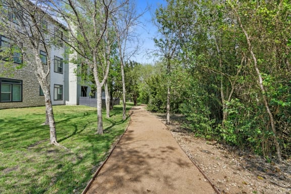 a dirt path with trees and buildings on the side of it at Radius on Grove, Austin, TX, 78741