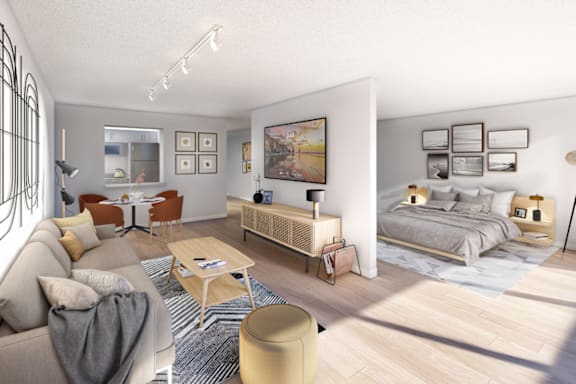 A modern living room with a grey sofa, a wooden coffee table, and a large bed with white bedding at Columbus Plaza, Chicago, IL