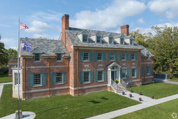 a large brick house with an flag on the lawn