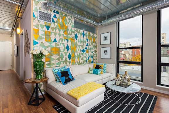 a living room with a white couch and a table with a vase