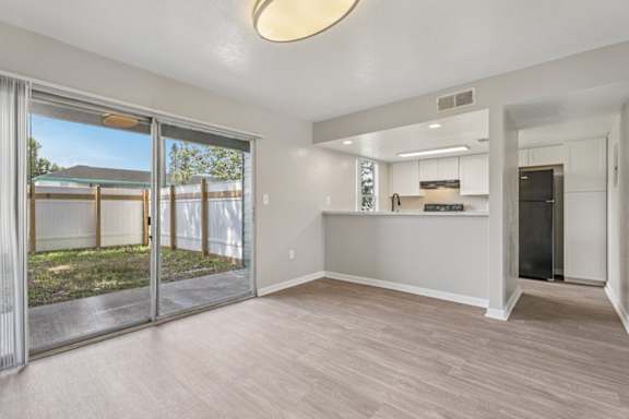 A spacious room with a sliding glass door leading to a backyard.