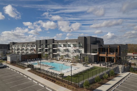 an apartment building with a swimming pool in front of it